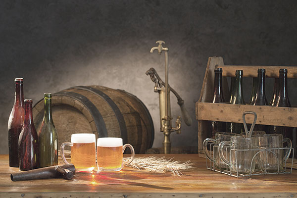 Bild som representerar ölets storhetstiden med gamla flaskor, fat och glas